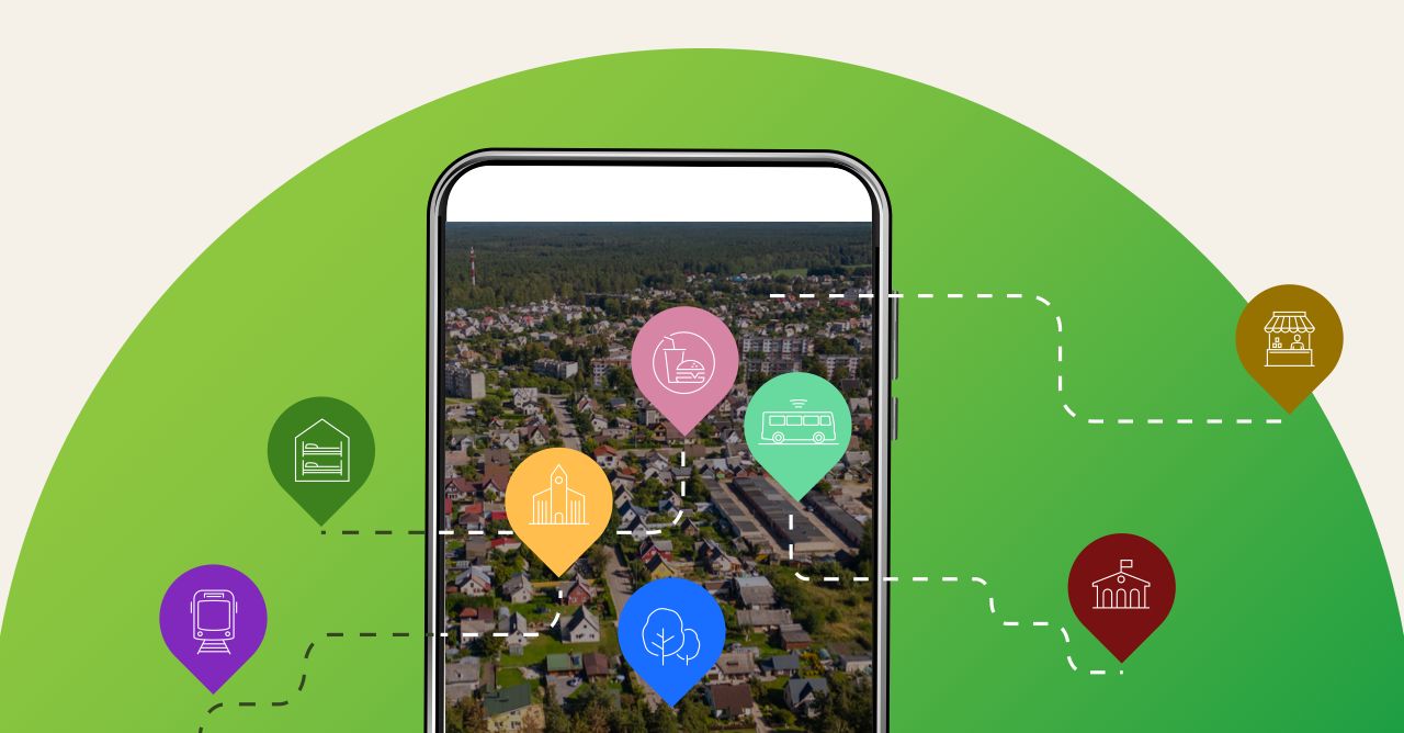 Telefonas su Kazlų Rūdos vaizdu iš paukščio skrydžio ir spalvotais žemėlapio smeigtukais aplink
